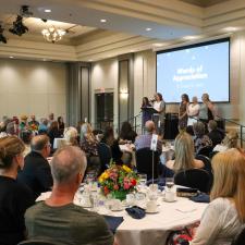 Photo of guests sitting at their tables and looking at those on stage