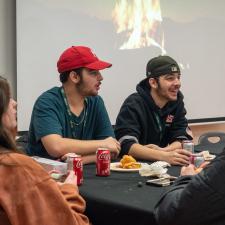 Students sitting at a table for lunch, having a conversation and smiling