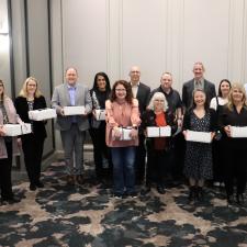 Group of employees holding white boxes, celebrating years of service